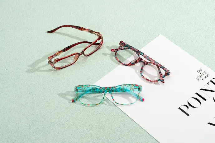 Three pairs of glasses sitting on top of a piece of paper